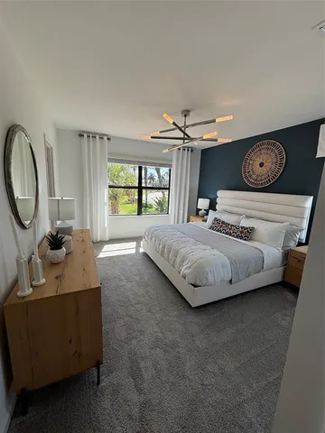 a bedroom with a bed a window and dresser