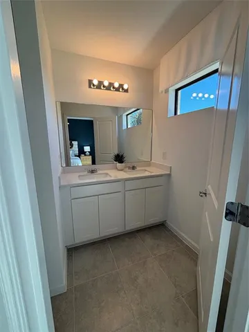 a bathroom with a double vanity sink a mirror and a bathtub