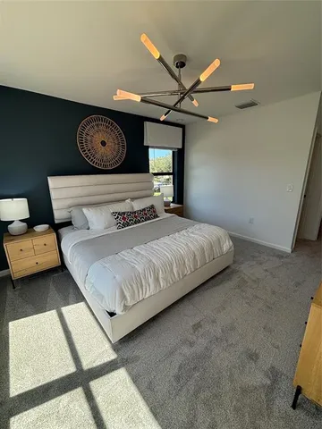 a bedroom with a bed and a chandelier