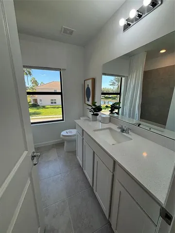 a bathroom with a sink a vanity and a large mirror