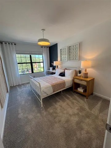 a spacious bedroom with a bed and a chandelier