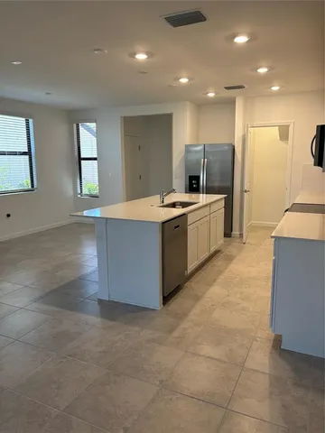 a kitchen with kitchen island a sink stove and refrigerator
