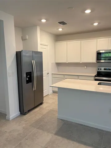a kitchen with stainless steel appliances a refrigerator and a stove top oven
