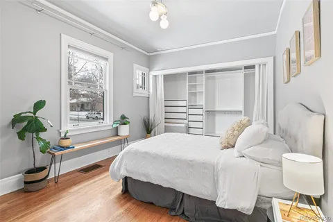 a bedroom with a bed and a potted plant