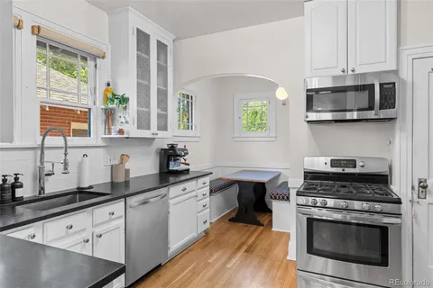 a kitchen with cabinets stainless steel appliances a sink and a window
