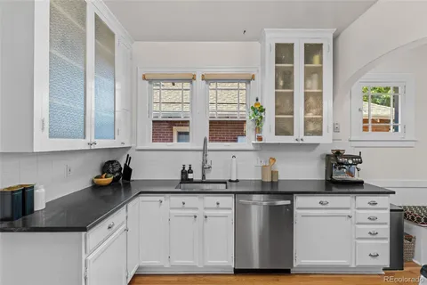 a kitchen with stainless steel appliances granite countertop a sink a stove and a window