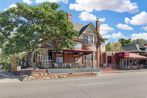 a view of a white building with a yard