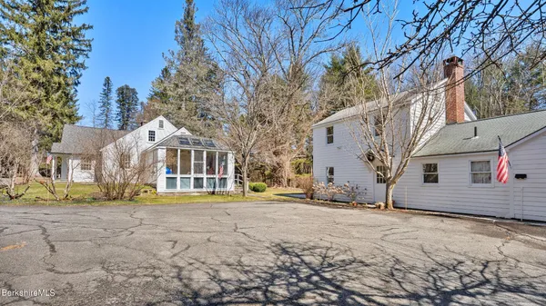 a view of a white house with a yard covered in snow