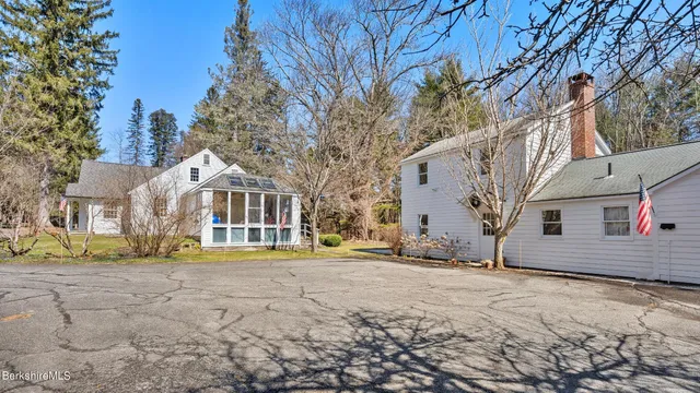a view of a white house with a yard covered in snow