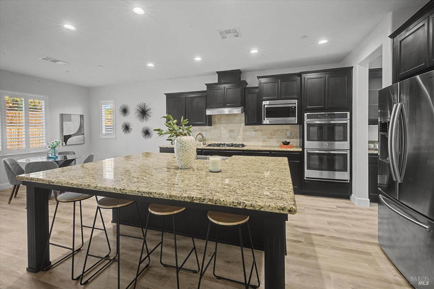 685 Elderberry Loop Vacaville, CA 95688 - Photo 20 of 73 a kitchen with stainless steel appliances granite countertop a kitchen island a stove a refrigerator a oven a dining table and chairs