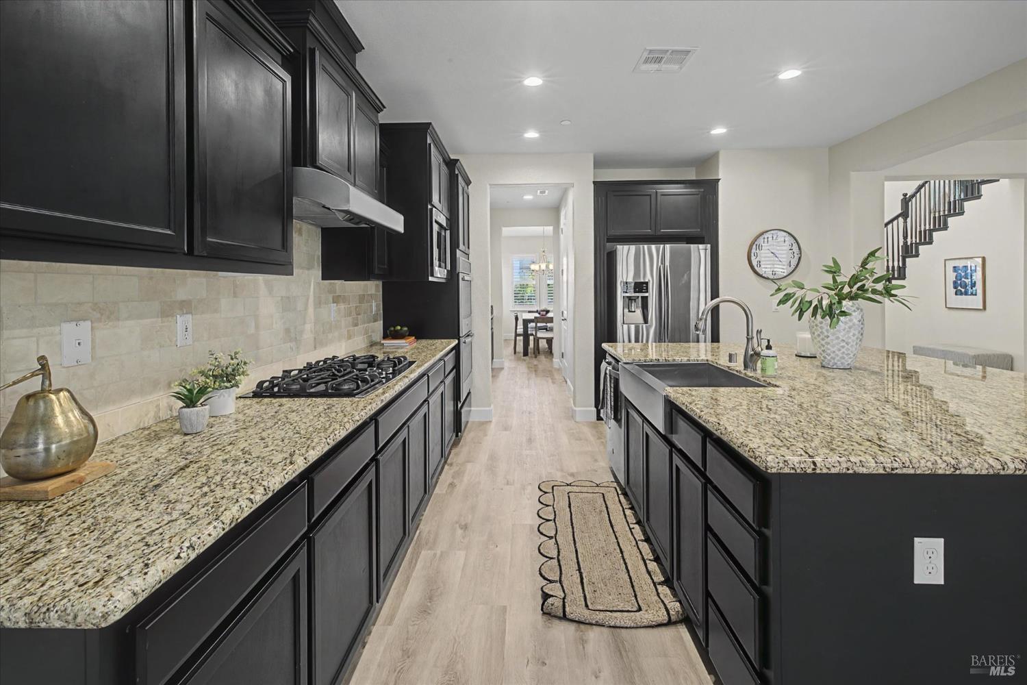 685 Elderberry Loop Vacaville, CA 95688 - Photo 23 of 73 a kitchen with granite countertop kitchen island stainless steel appliances a sink stove top oven and cabinets
