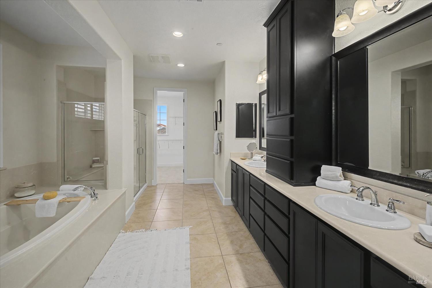685 Elderberry Loop Vacaville, CA 95688 - Photo 50 of 73 a bathroom with double vanity sinks a large mirror and a shower