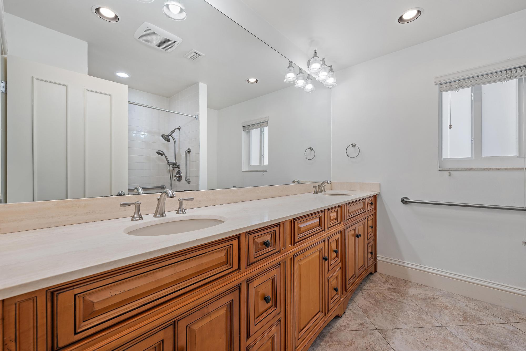 1504 Captains Way Jupiter, FL 33477 - Photo 17 of 51 a bathroom with double vanity and a mirror