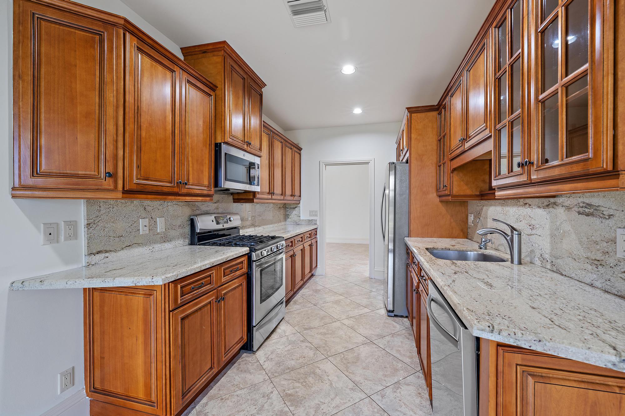1504 Captains Way Jupiter, FL 33477 - Photo 6 of 51 a kitchen with stainless steel appliances granite countertop a sink stove and cabinets