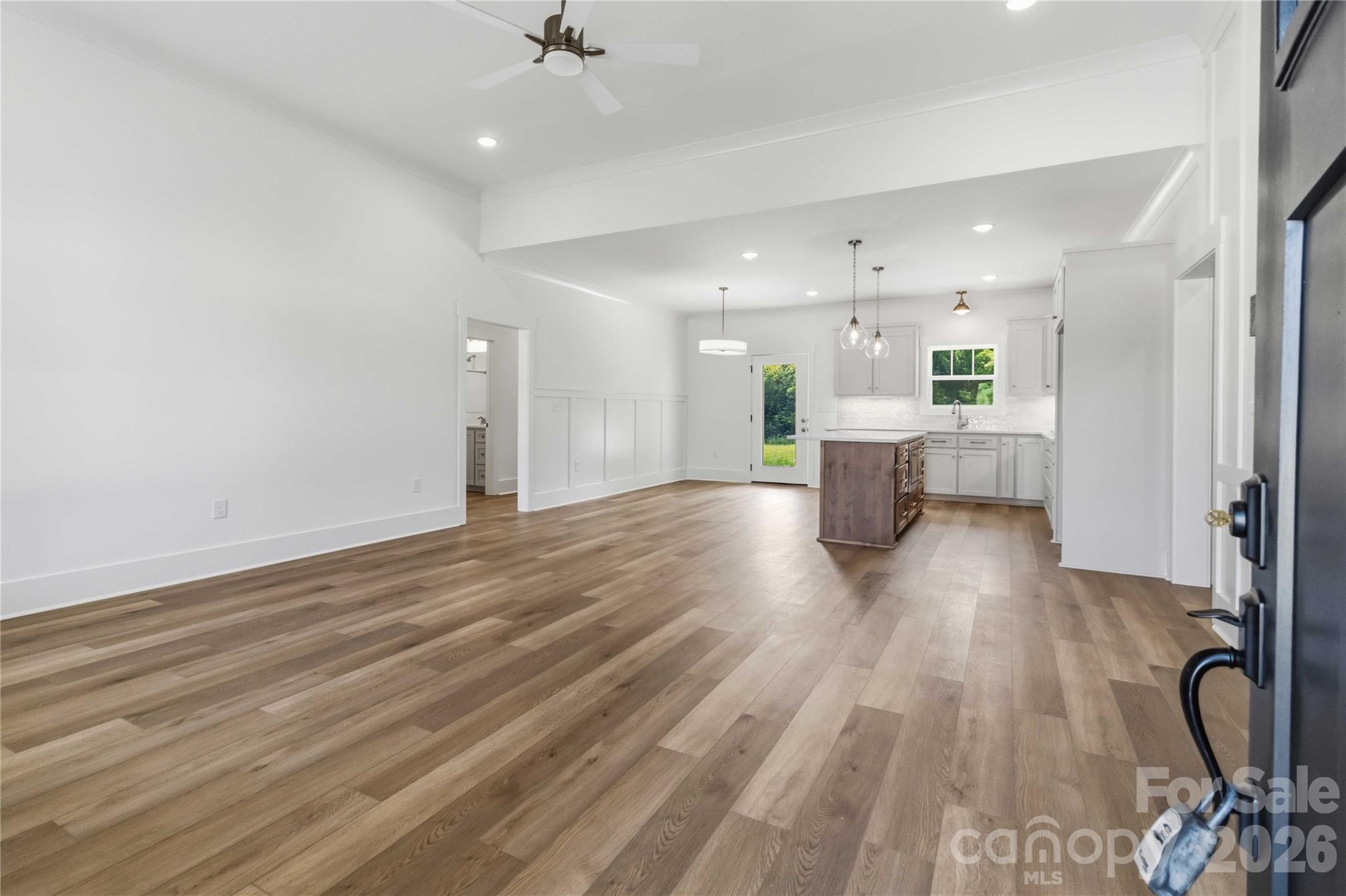 352 Adams Road Clover, SC 29710 - Photo 3 of 38 a view of a kitchen with kitchen island a sink wooden floor and stainless steel appliances
