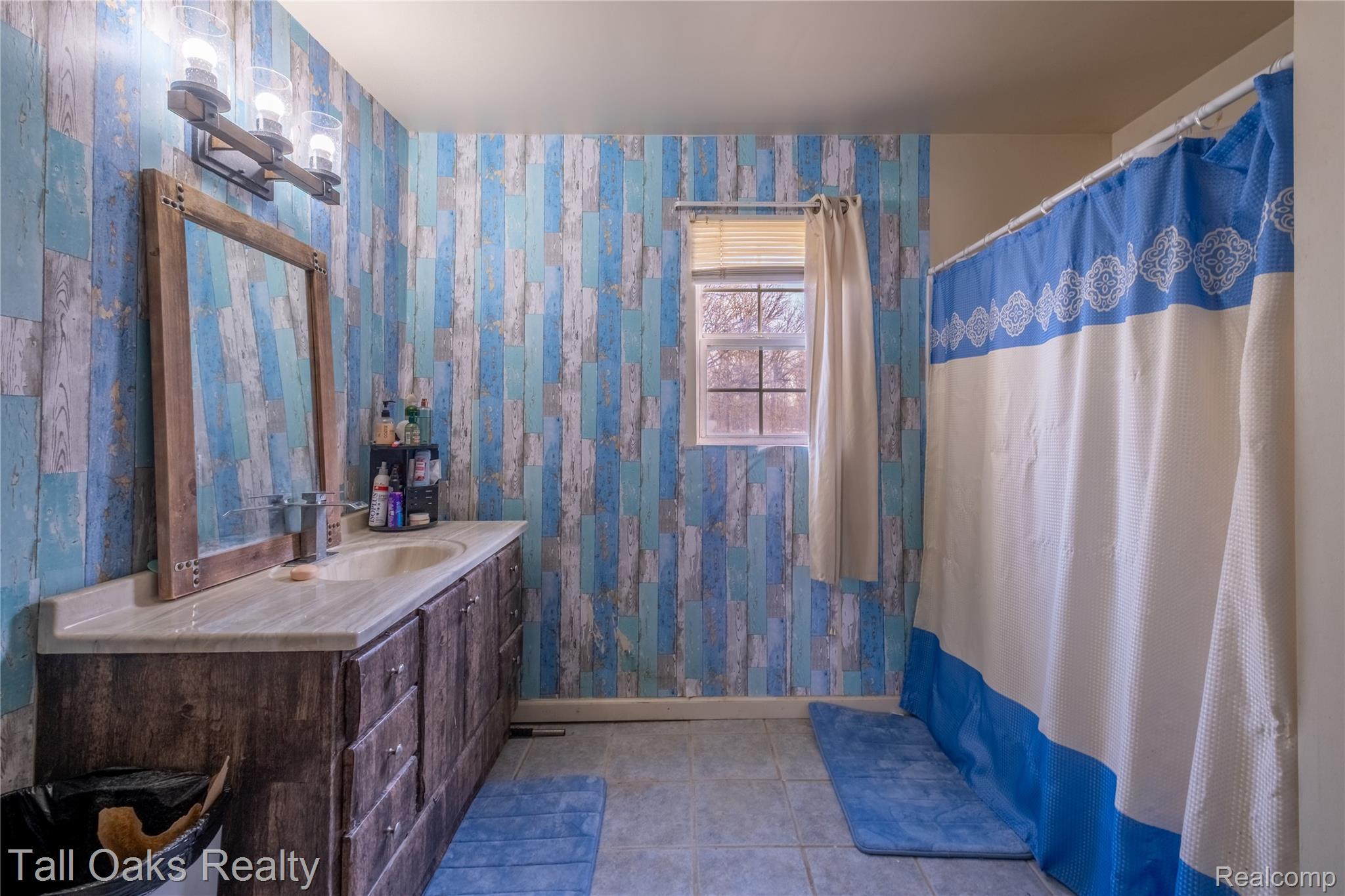 6054 East Pierson Road Flint, MI 48506 - Photo 29 of 38 Bathroom featuring a shower with curtain, wallpapered walls, vanity, and light tile patterned floors