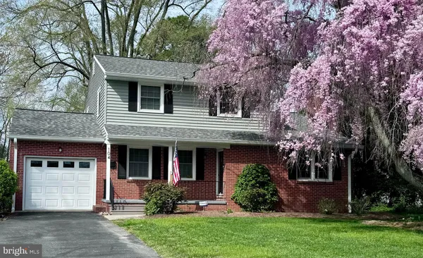 a view of a house with a yard and large tree