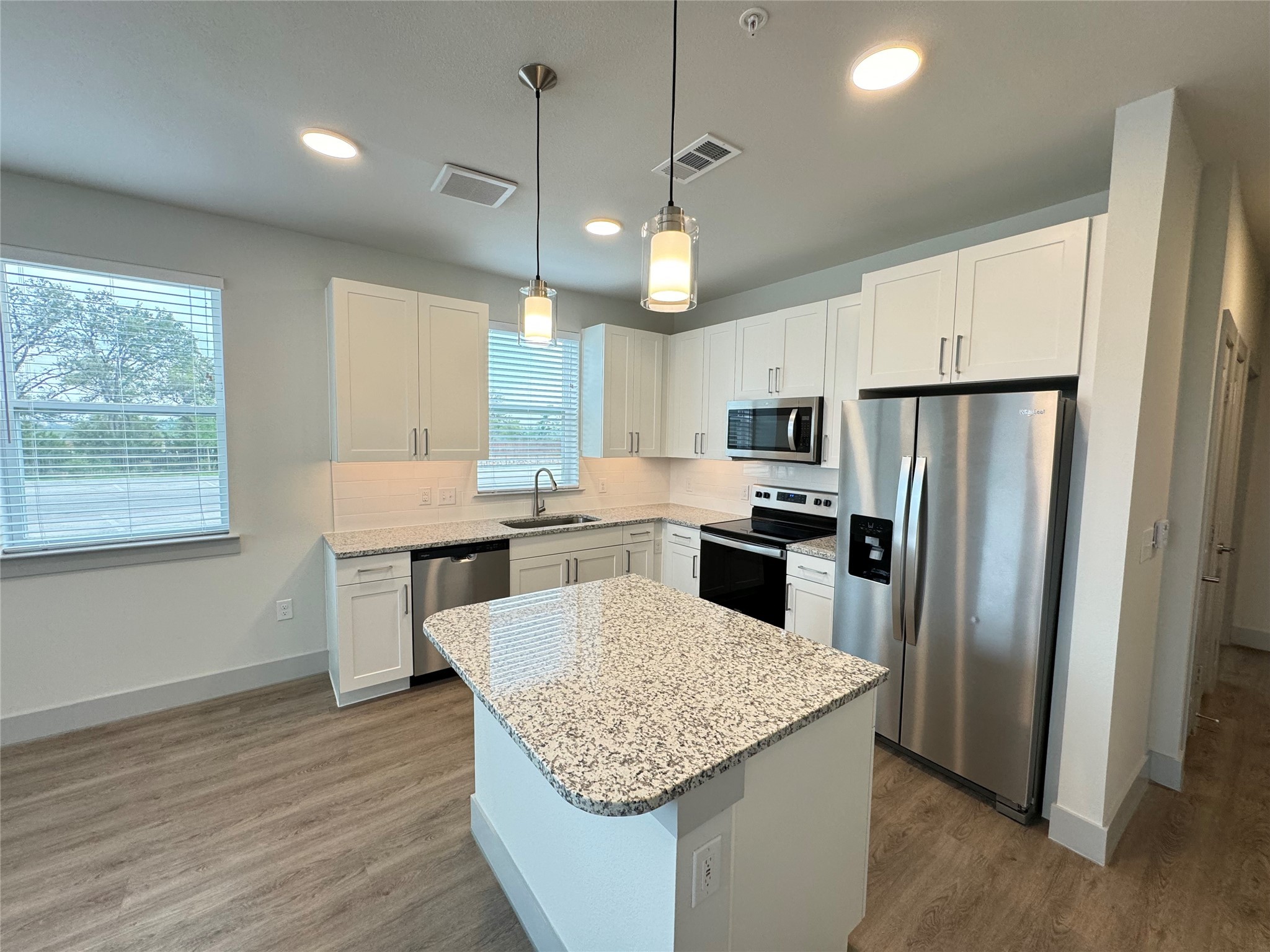 29600 Ronald Reagan Boulevard, Unit B4 6307 Georgetown, TX 78633 - Photo 2 of 10 a kitchen with granite countertop stainless steel appliances a refrigerator a stove a sink cabinets and wooden floor