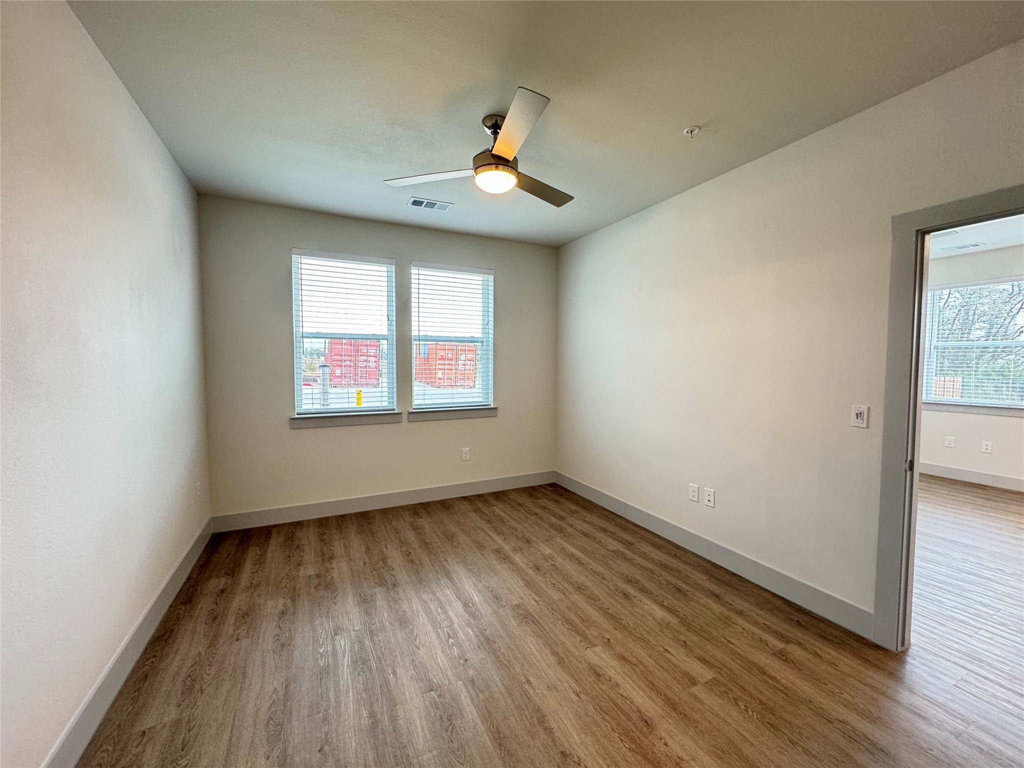 29600 Ronald Reagan Boulevard, Unit B4 6307 Georgetown, TX 78633 - Photo 6 of 10 an empty room with wooden floor chandelier and windows