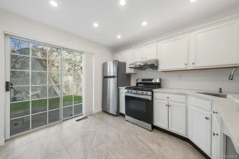 a kitchen with stainless steel appliances granite countertop a stove a sink and a refrigerator