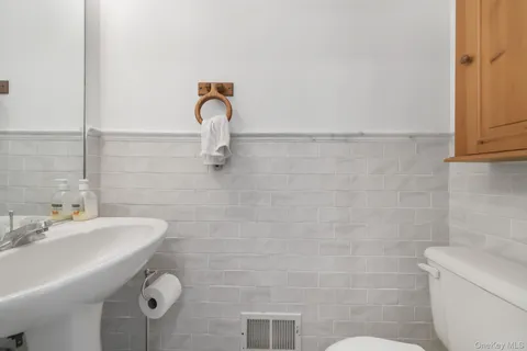 a bathroom with a sink a toilet and mirror