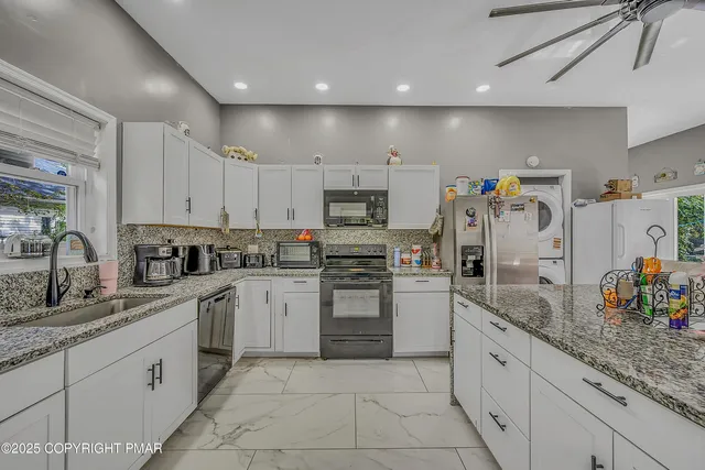 a kitchen with granite countertop stainless steel appliances and white cabinets