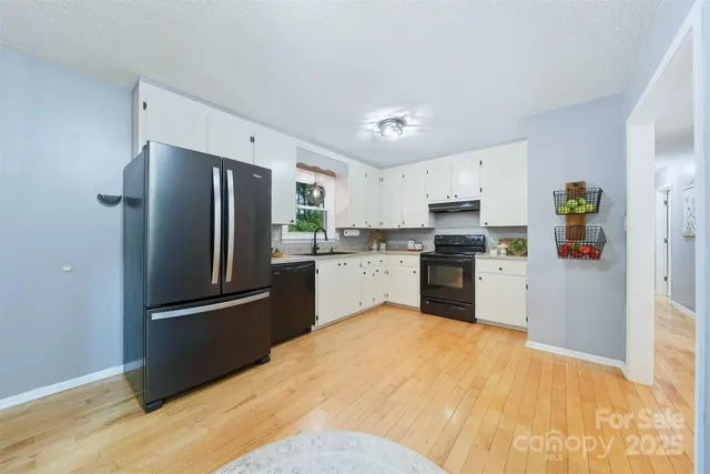 a kitchen with granite countertop white cabinets and stainless steel appliances