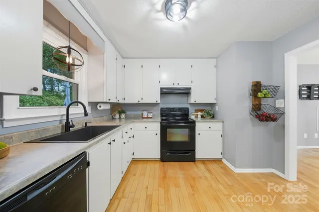 a kitchen with granite countertop a sink stainless steel appliances and cabinets
