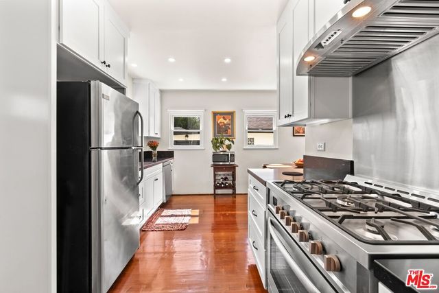 a kitchen with stainless steel appliances granite countertop a refrigerator a stove and a sink