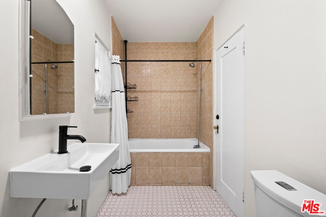 910 North Bushnell Avenue Alhambra, CA 91801 - Photo 18 of 23 a bathroom with a sink a toilet a shower and mirror
