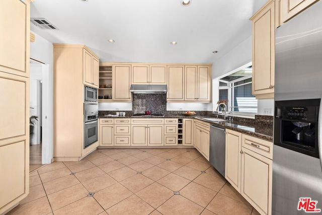 a large white kitchen with cabinets a sink and white appliances