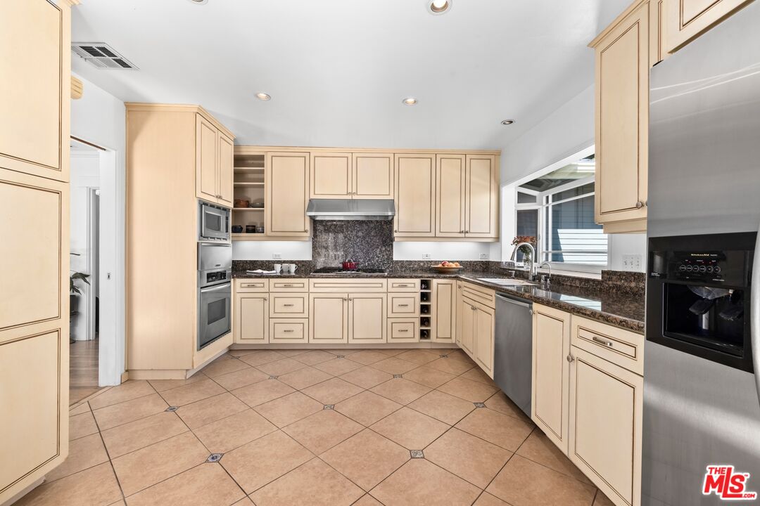 910 North Bushnell Avenue Alhambra, CA 91801 - Photo 6 of 23 a large white kitchen with cabinets a sink and white appliances