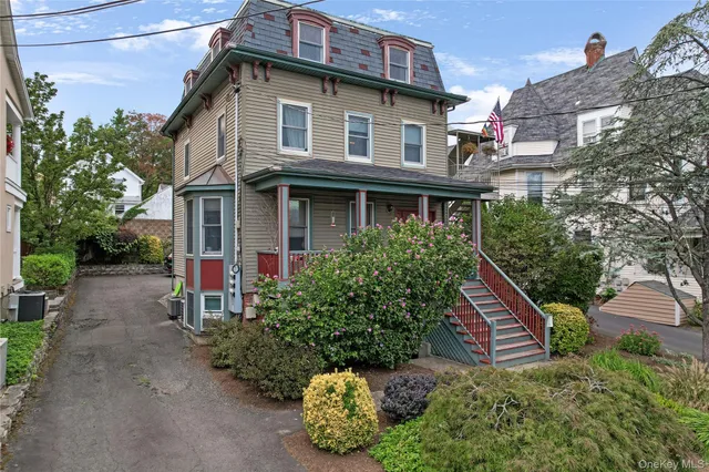 a view of a house with a yard and potted plants