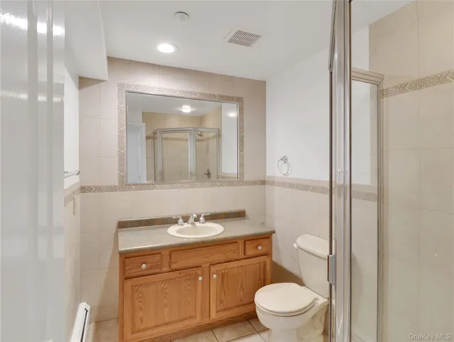 a bathroom with a granite countertop sink toilet a mirror and a shower