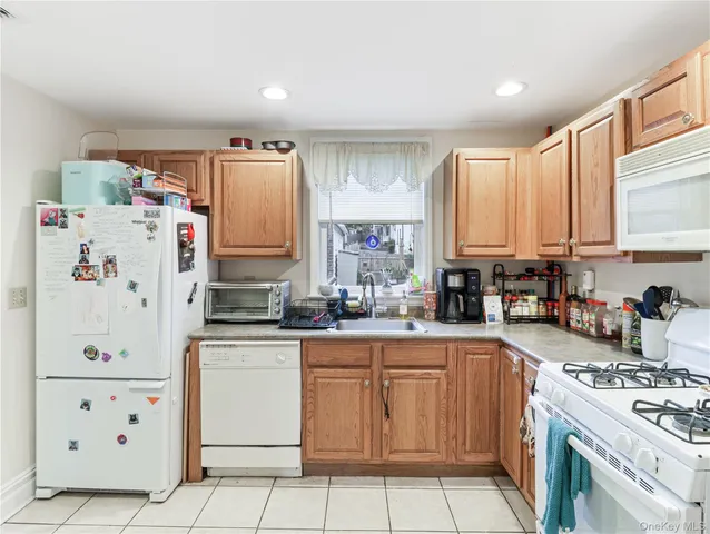a kitchen with granite countertop cabinets and white appliances