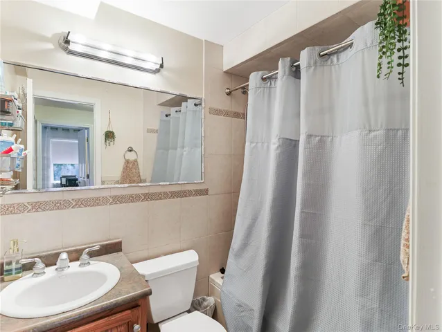 a bathroom with a sink toilet a mirror a vanity and shower