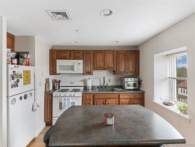 a kitchen with stainless steel appliances granite countertop a refrigerator sink and stove