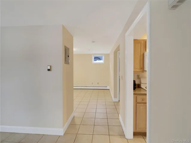 a view of a hallway with wooden floor and a bathroom