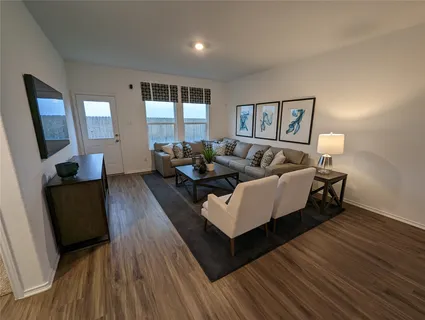 a living room with furniture and a wooden floor