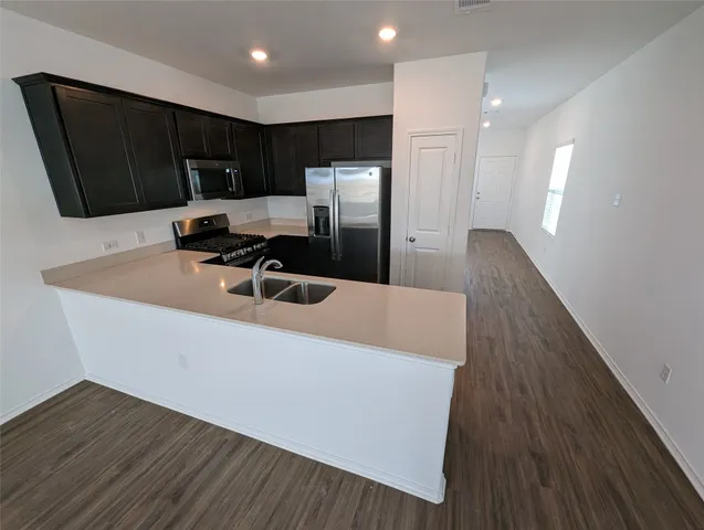 a kitchen with stainless steel appliances a refrigerator sink and microwave