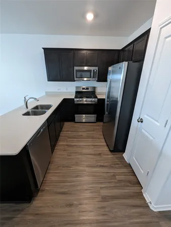 a kitchen with a sink a refrigerator and trees