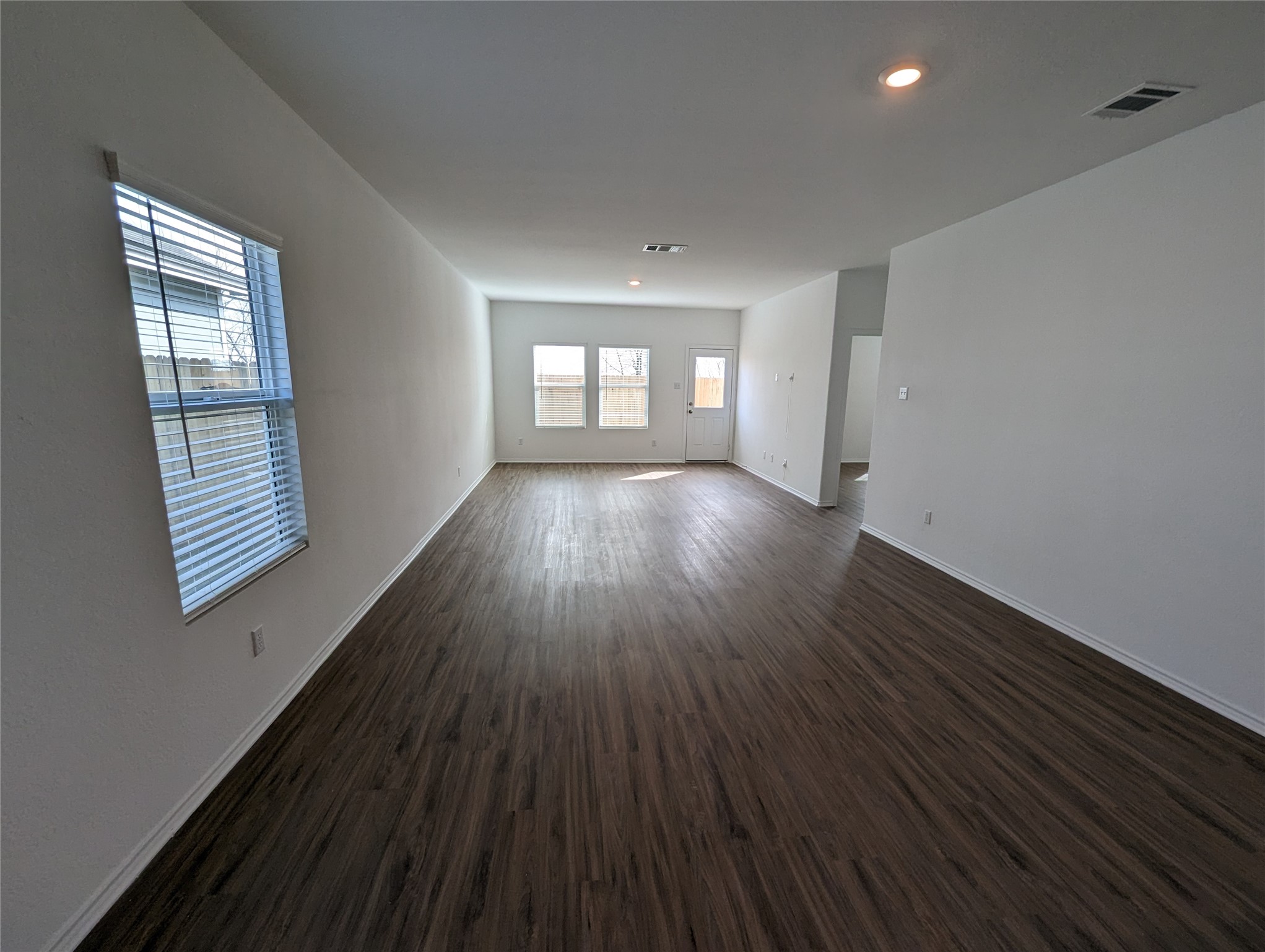 361 Soapstone Pass Maxwell, TX 78656 - Photo 10 of 17 an empty room with wooden floor and windows