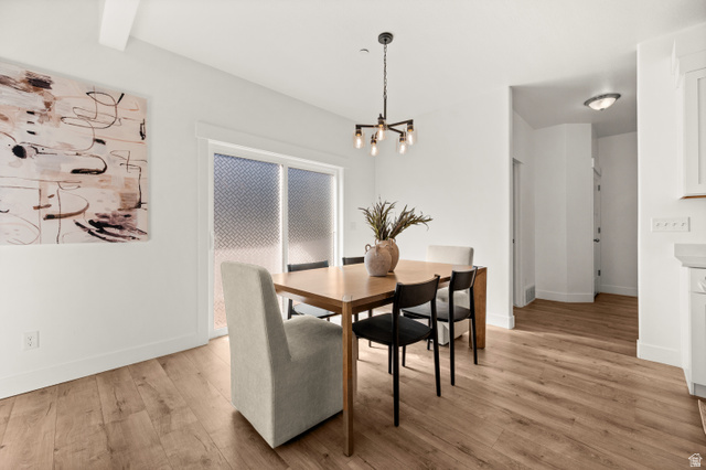 14728 South Canyon Pointe Road Draper, UT 84020 - Photo 12 of 35 Dining area featuring wood-finish flooring, white walls, and a modern chandelier