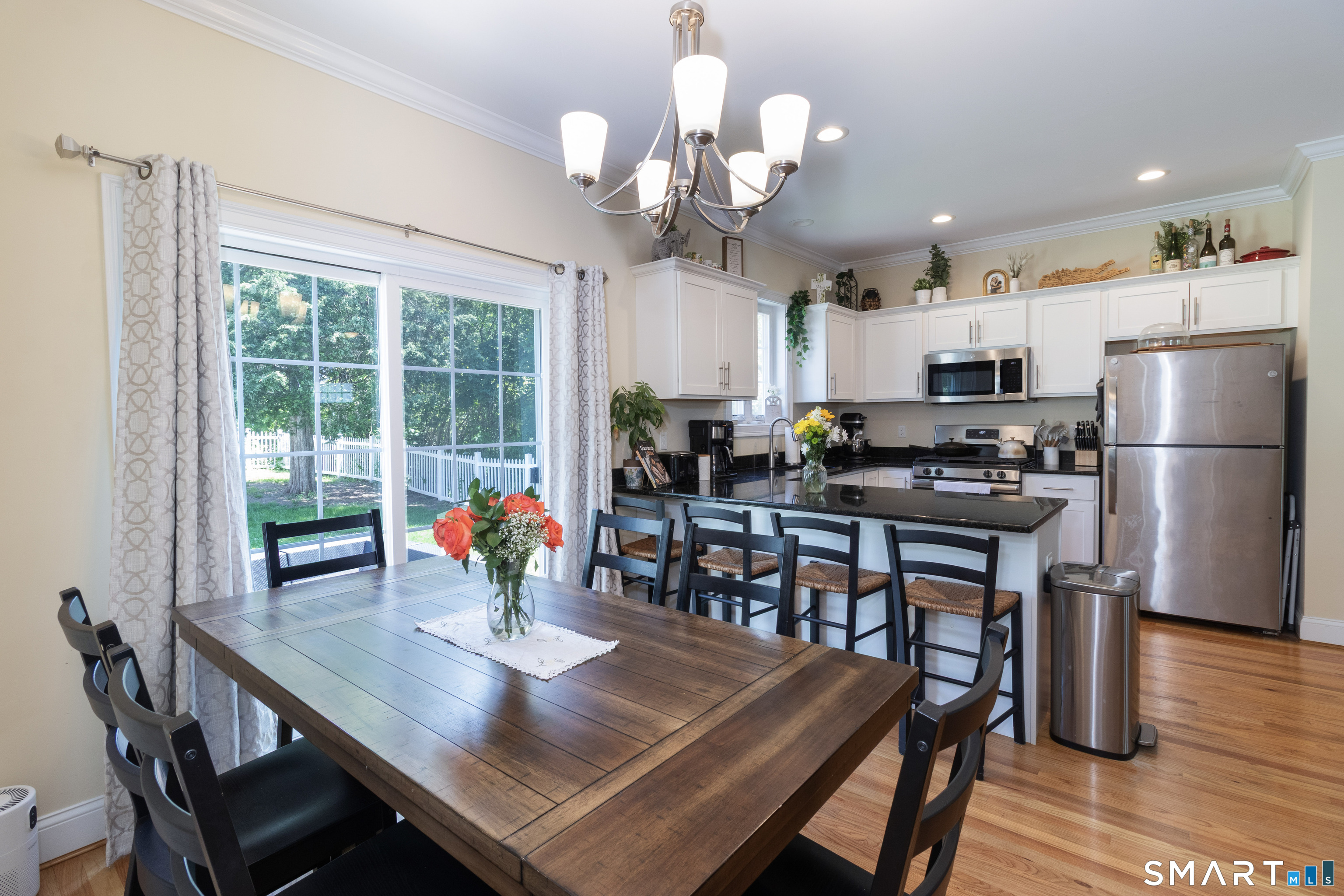 656 Bartholomew Road, Unit 656 Middletown, CT 06457 - Photo 17 of 27 a view of a dining room with furniture a chandelier wooden floor and chandelier