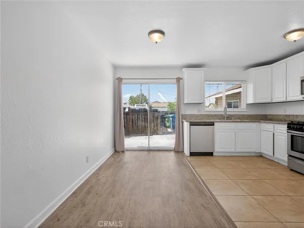 a large white kitchen with a stove top oven a sink and dishwasher