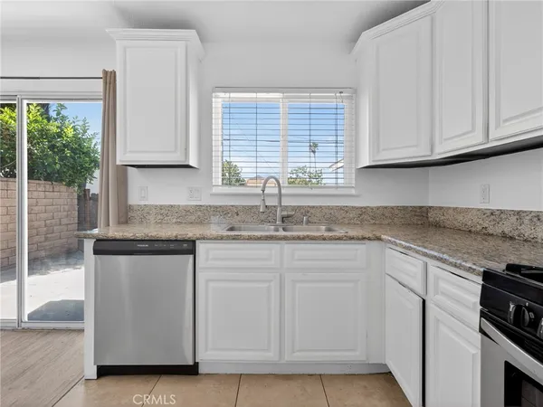 a kitchen with granite countertop white cabinets and white appliances