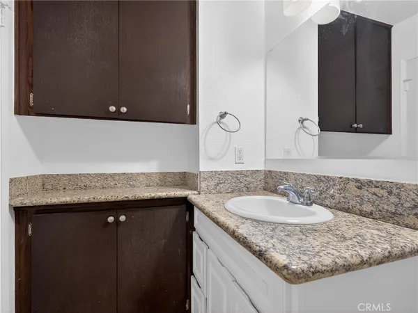a bathroom with a granite countertop sink and a mirror