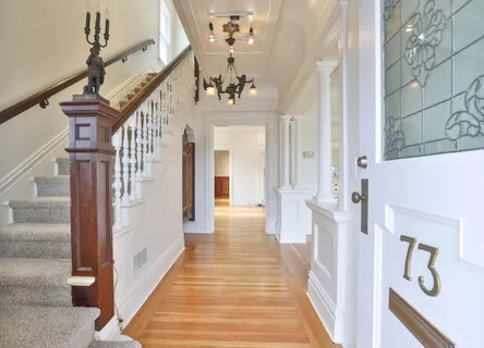 a view of a hallway with wooden floor and staircase