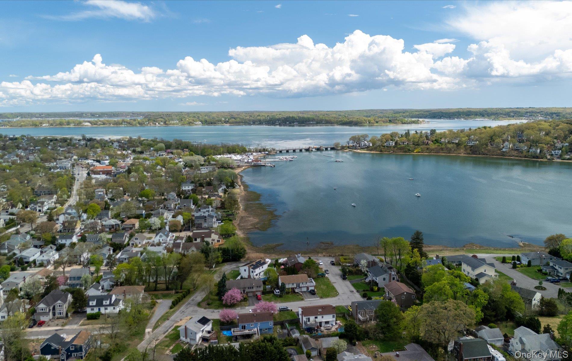 16 East Slope Road Bayville, NY 11709 - Photo 46 of 48 Expansive aerial perspective showcasing a coastal community with residential properties, verdant trees, and a body of water