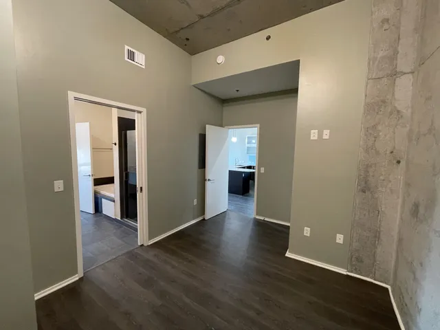 an empty room with wooden floor and entrance